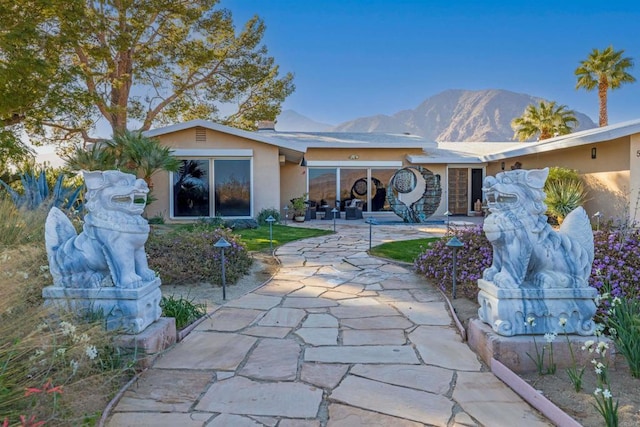 back of house featuring a mountain view and a patio