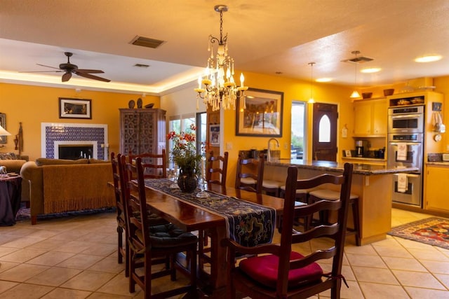 dining room featuring light tile patterned floors, a wealth of natural light, and ceiling fan with notable chandelier