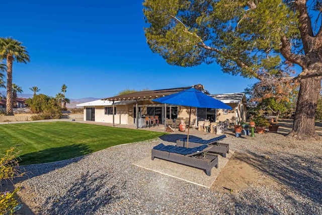 rear view of house with a lawn and a patio area