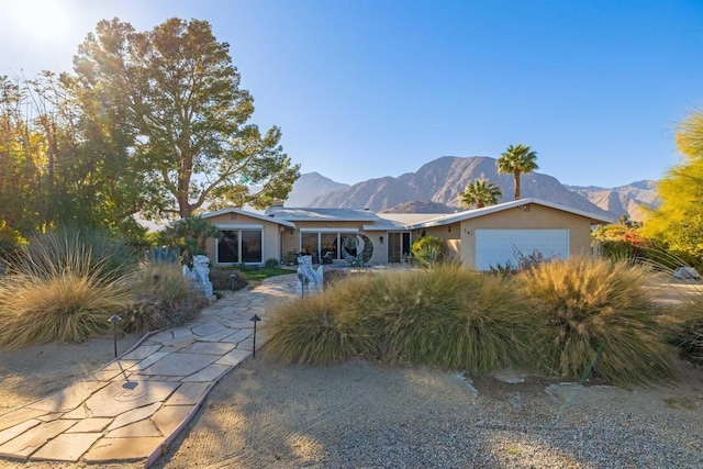 view of front facade with a garage and a mountain view