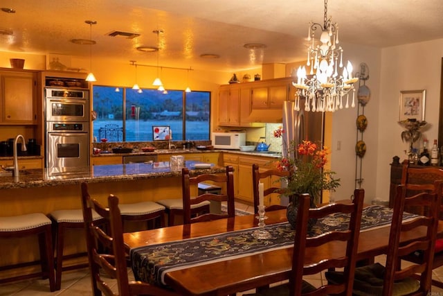 dining room with a chandelier and light tile patterned flooring