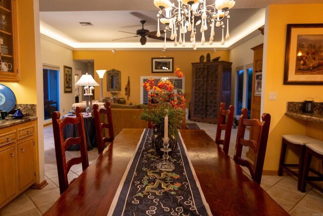 dining room featuring light tile patterned floors and ceiling fan with notable chandelier