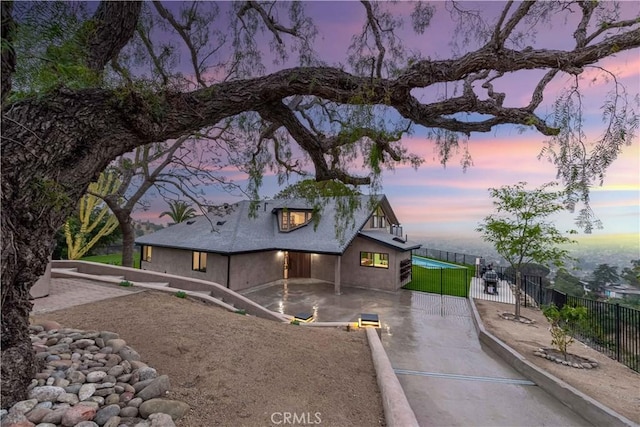 property exterior at dusk featuring a patio area