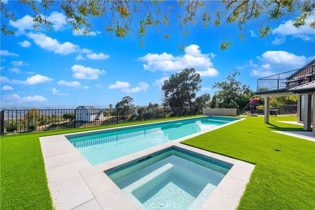 view of pool with an in ground hot tub and a lawn