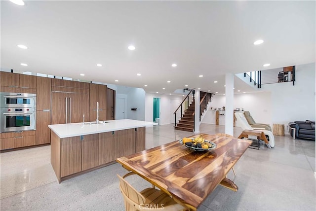 kitchen with double oven, a large island, and sink