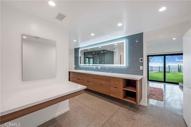 bathroom featuring a shower, backsplash, and vanity