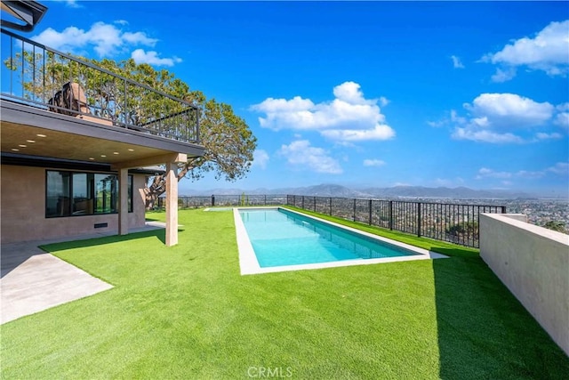 view of pool with a lawn and a mountain view