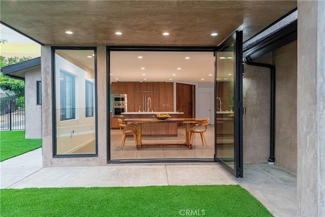 exterior entry at dusk featuring a patio area and sink