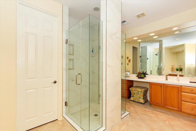 bathroom with walk in shower, vanity, and tile patterned floors