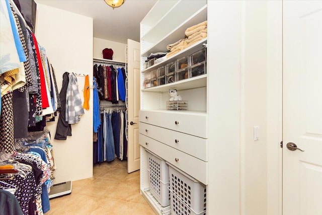 spacious closet featuring a baseboard radiator and light tile patterned floors