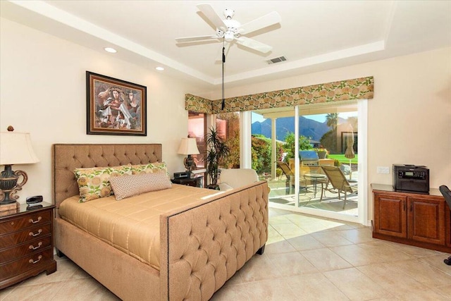 tiled bedroom with ceiling fan, access to exterior, and a tray ceiling