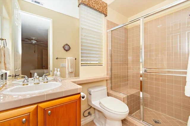 bathroom with ceiling fan, toilet, a shower with shower door, and vanity