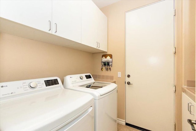 washroom with cabinets, separate washer and dryer, and light tile patterned flooring