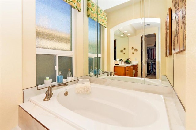 bathroom with tiled bath and vanity