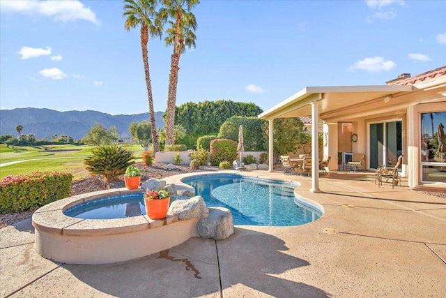 view of swimming pool with a mountain view, a hot tub, and a patio