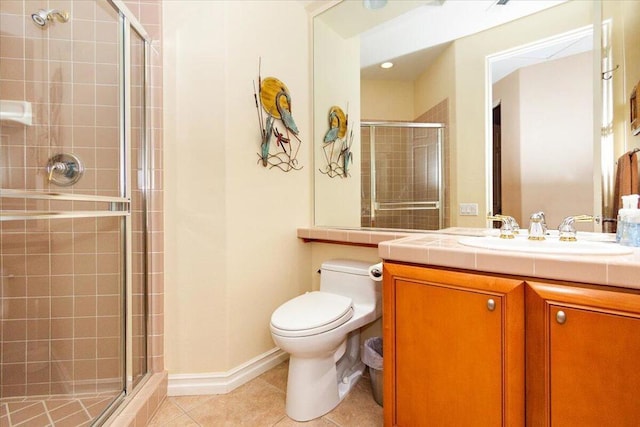 bathroom featuring a shower with shower door, toilet, vanity, and tile patterned flooring