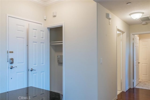 hallway with baseboards, ornamental molding, and dark wood finished floors