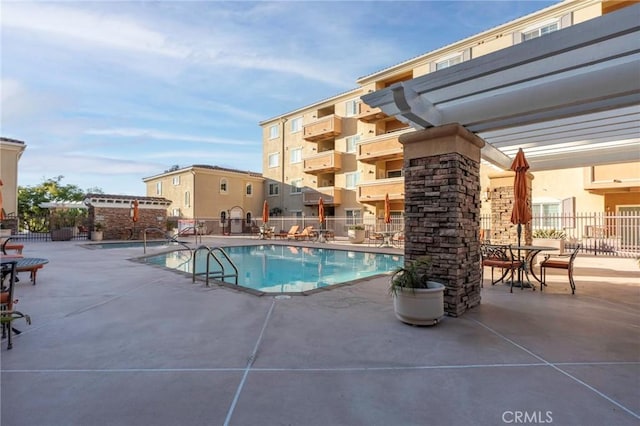 community pool featuring fence and a patio