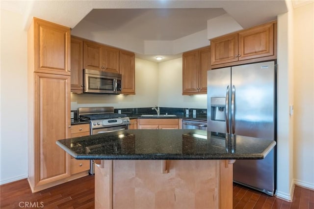 kitchen with stainless steel appliances, dark wood-style flooring, a sink, and baseboards