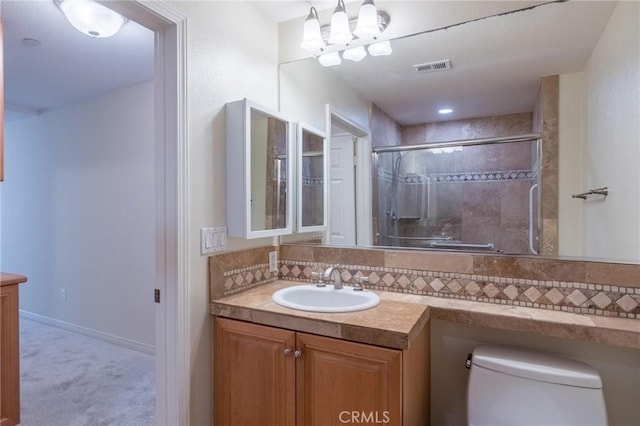 bathroom featuring tasteful backsplash, visible vents, toilet, vanity, and a shower stall