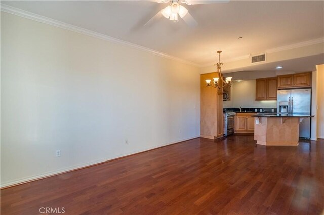 kitchen with dark wood-type flooring, visible vents, a kitchen breakfast bar, appliances with stainless steel finishes, and crown molding