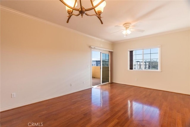 spare room featuring ceiling fan with notable chandelier, ornamental molding, wood finished floors, and baseboards