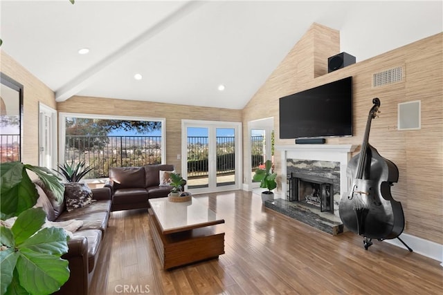 living room featuring hardwood / wood-style floors, a fireplace, high vaulted ceiling, and beamed ceiling