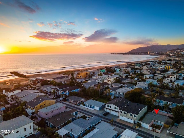 aerial view at dusk featuring a water view