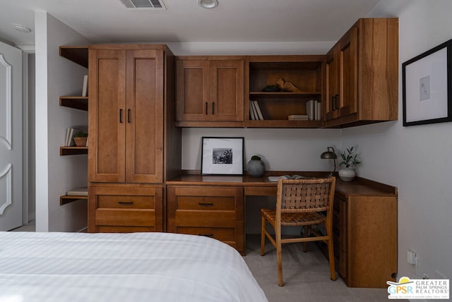 carpeted bedroom with built in desk