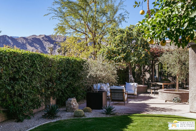 view of yard with a mountain view, an outdoor living space, and a patio area