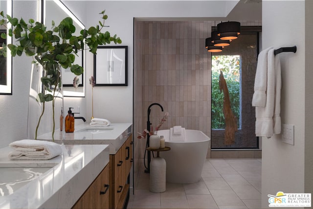 bathroom with tile patterned flooring, vanity, and a bath