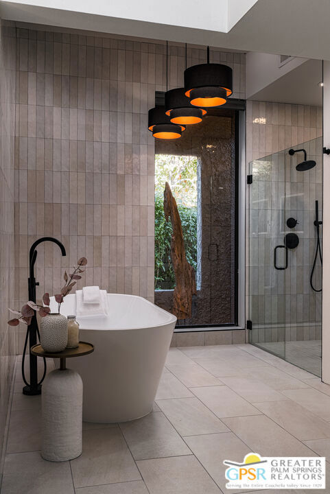 bathroom with tile patterned floors, shower with separate bathtub, and tile walls