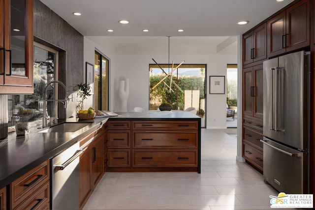 kitchen featuring hanging light fixtures, appliances with stainless steel finishes, sink, and kitchen peninsula