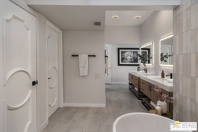 bathroom featuring vanity, a bath, and tile patterned flooring