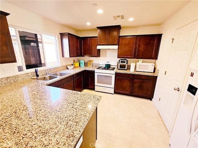 kitchen with light stone counters, sink, and white appliances