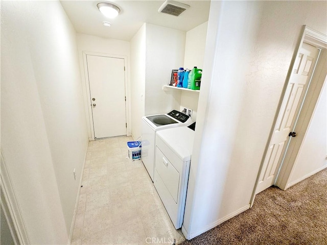 clothes washing area featuring light colored carpet and washing machine and clothes dryer