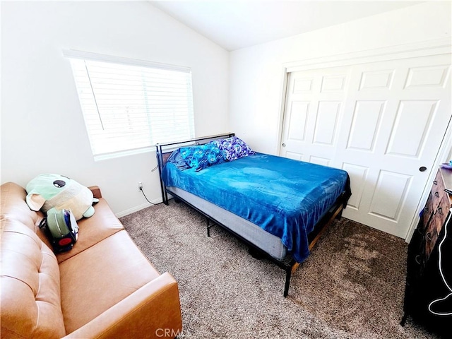 carpeted bedroom featuring a closet and lofted ceiling