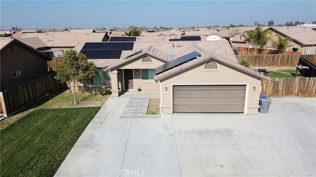 view of front facade featuring a garage, a front lawn, and solar panels