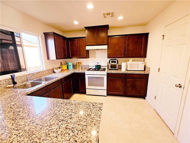 kitchen with light stone countertops, sink, and white appliances