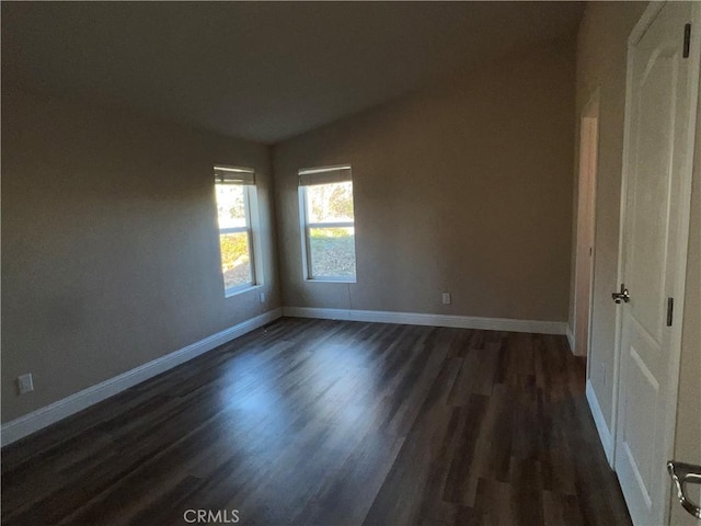 unfurnished room with dark wood-type flooring and vaulted ceiling