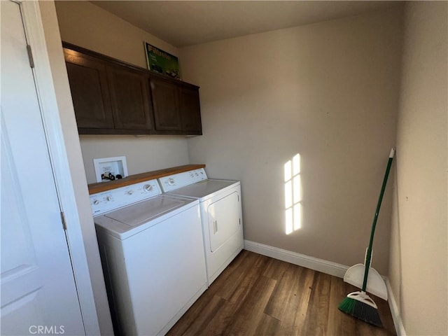 washroom with washing machine and dryer, dark hardwood / wood-style floors, and cabinets