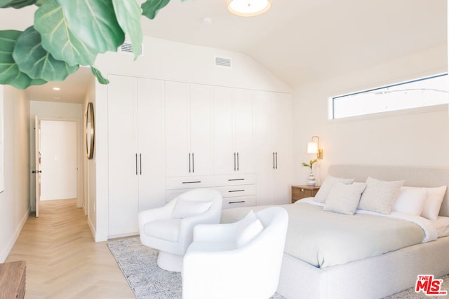 bedroom featuring light parquet flooring, a closet, and vaulted ceiling