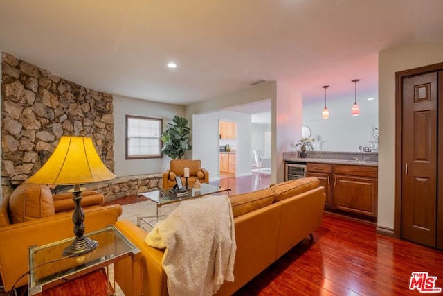 living room with dark wood-type flooring, sink, and beverage cooler