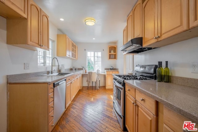 kitchen featuring appliances with stainless steel finishes, light brown cabinetry, light hardwood / wood-style floors, and sink