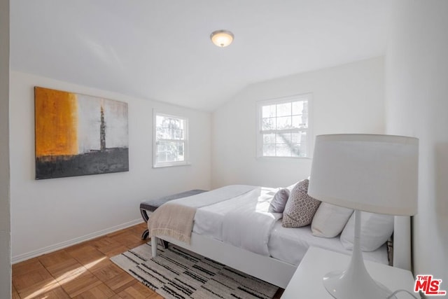 bedroom with vaulted ceiling and light parquet floors