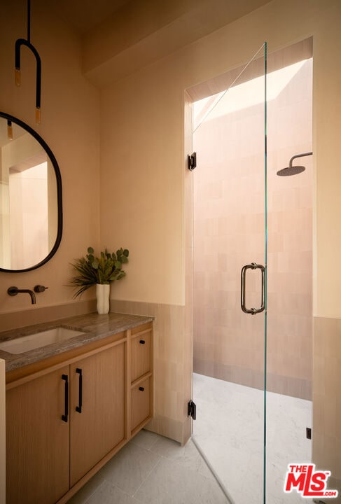 bathroom with tile patterned floors, an enclosed shower, and vanity