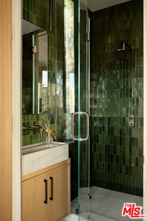 bathroom with walk in shower, sink, and tile patterned floors