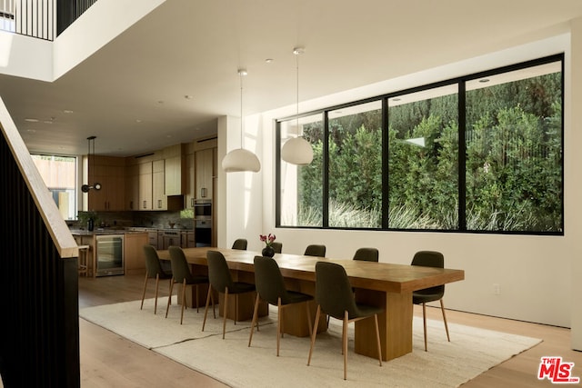 dining room with beverage cooler and light wood-type flooring