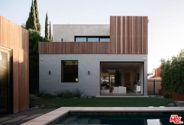 rear view of house featuring an outdoor hangout area, a fenced in pool, a lawn, and a patio