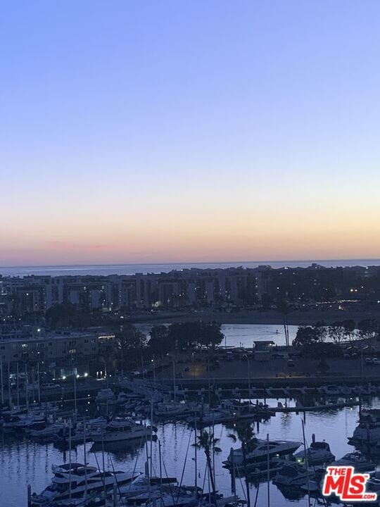 aerial view at dusk featuring a water view